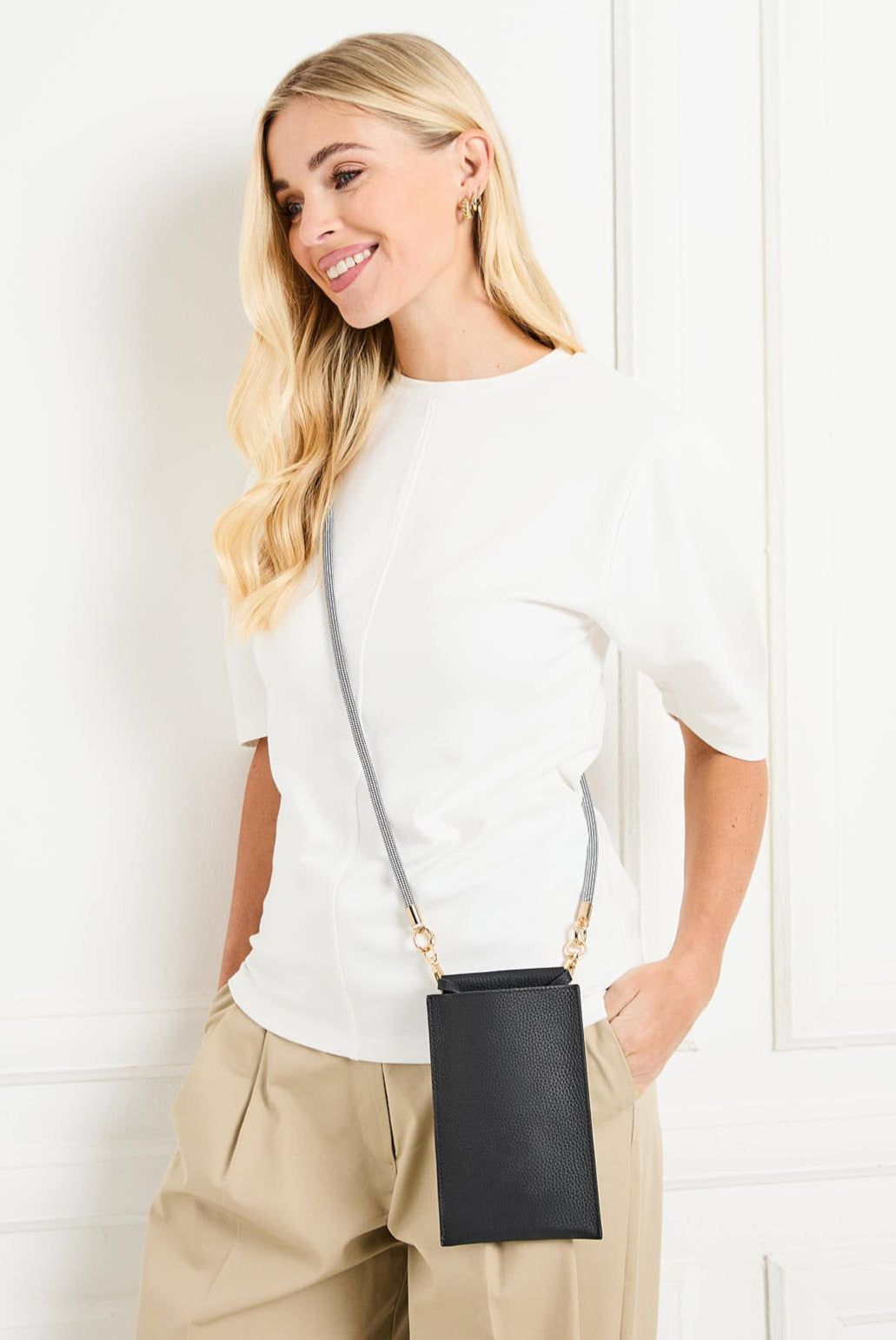 Image of a Model displaying the Black Leather Phone Pouch for Women by Elie Beaumont